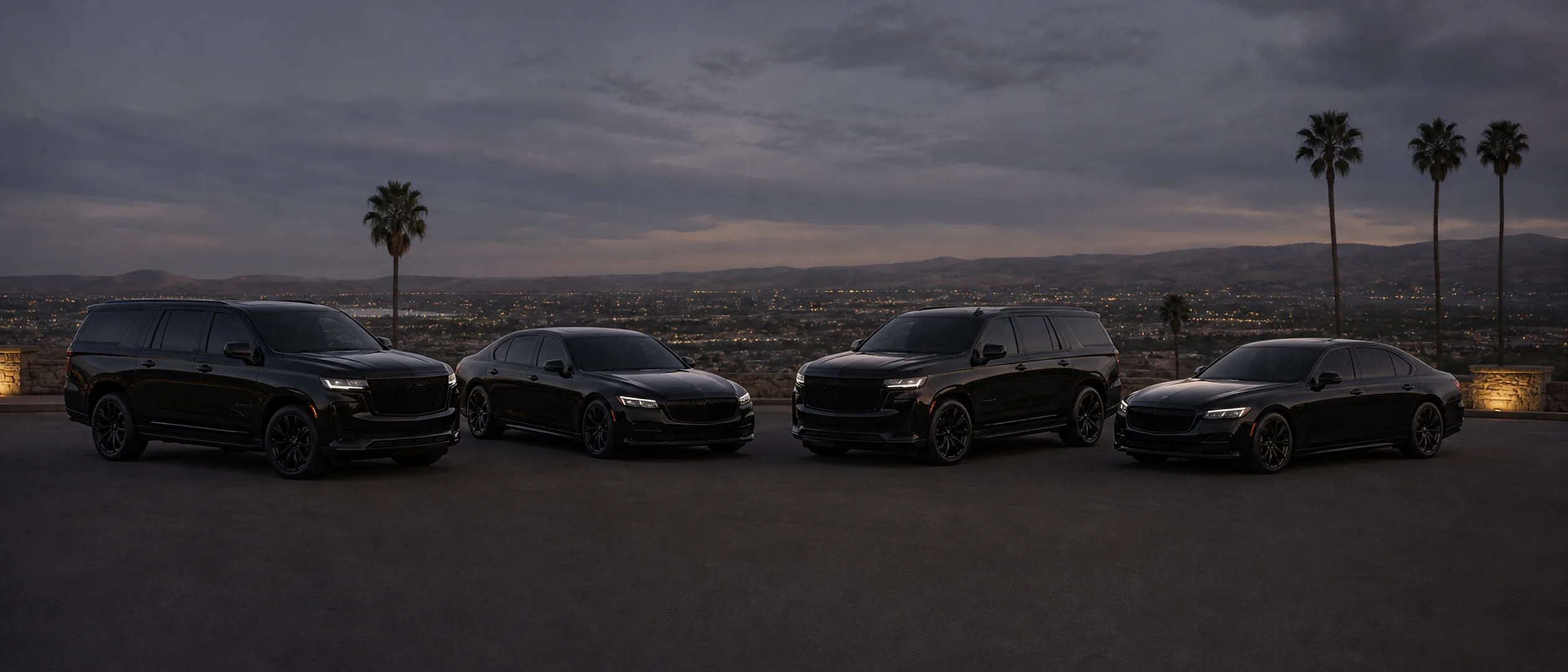 Four black Ride Lux vehicles parked in an arc at Bakersfield's Panorama Bluffs at dusk.